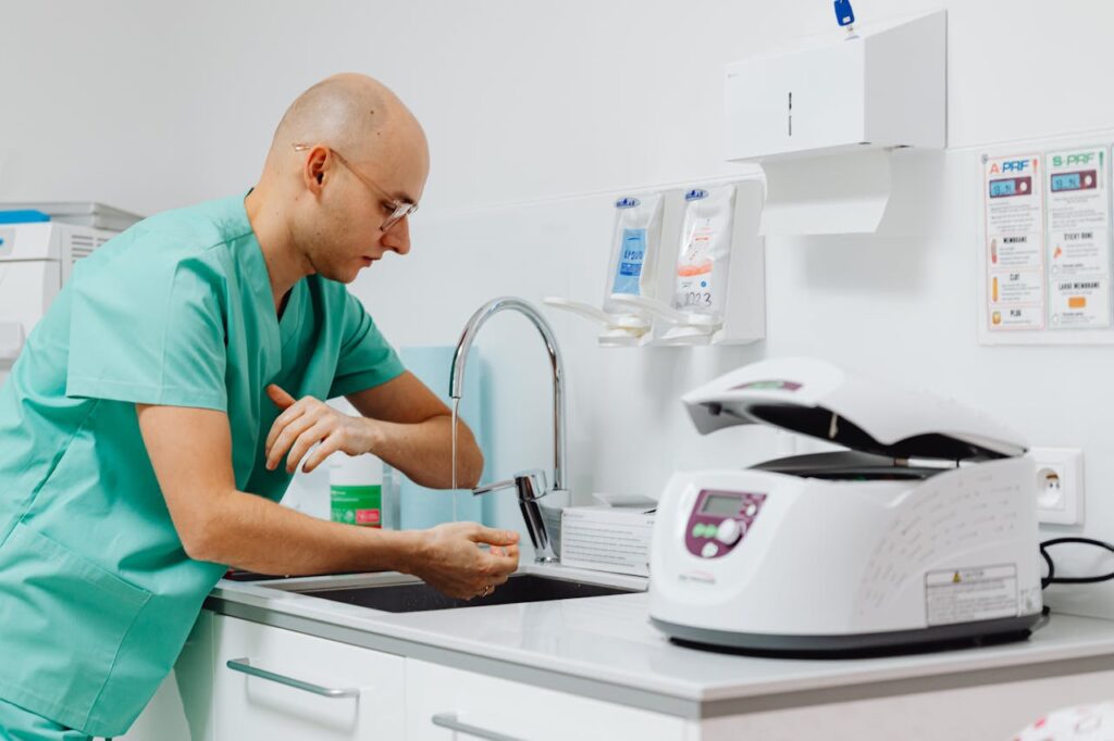 pexels photo 6627781 A medical professional practicing hand hygiene in a clinical setting.